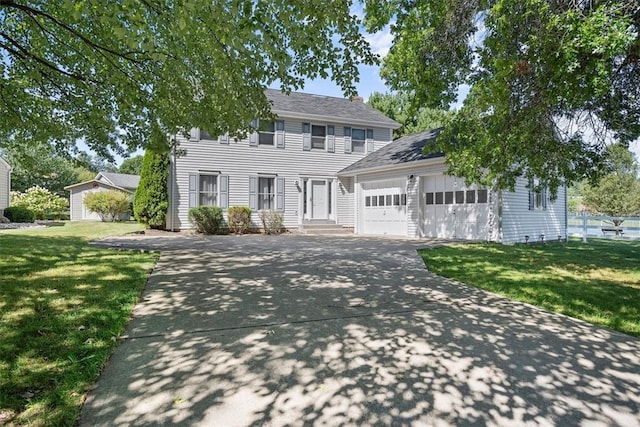 colonial home with a front lawn and a garage