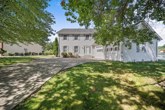 colonial home with a front yard, a garage, and a balcony