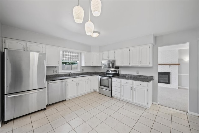 kitchen featuring stainless steel appliances, pendant lighting, and white cabinets