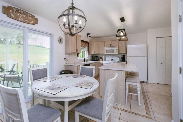 tiled dining area featuring a notable chandelier and sink