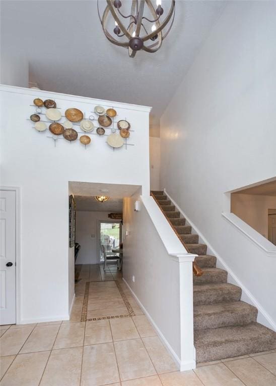 stairway featuring tile patterned floors and a high ceiling