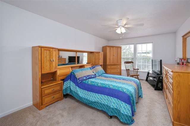 carpeted bedroom with a textured ceiling and ceiling fan