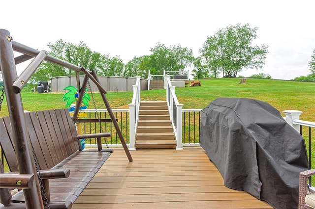 deck with a playground, area for grilling, and a lawn