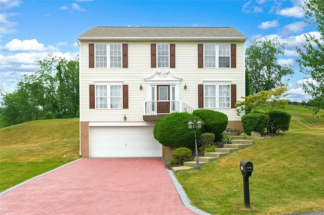 colonial home with a garage and a front yard