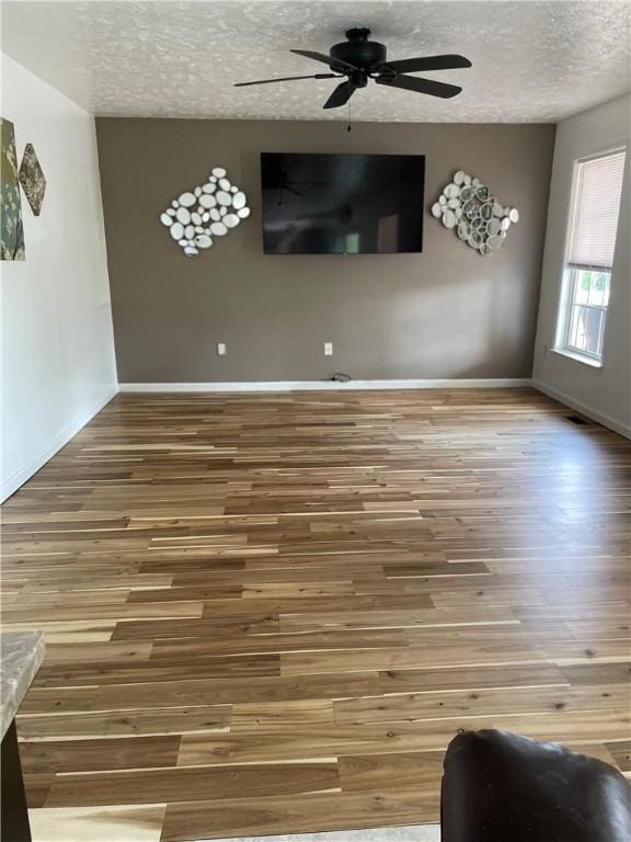 interior space featuring wood-type flooring, a textured ceiling, and ceiling fan