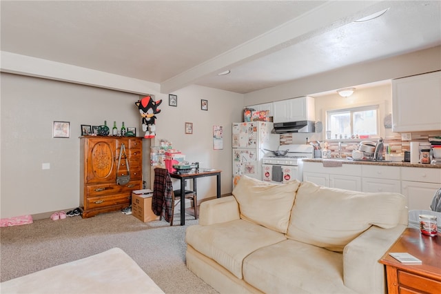 living room featuring beamed ceiling, sink, and light colored carpet