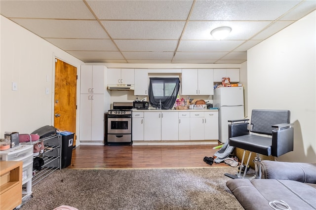 kitchen featuring stainless steel stove, dark wood-type flooring, white cabinetry, a paneled ceiling, and white refrigerator