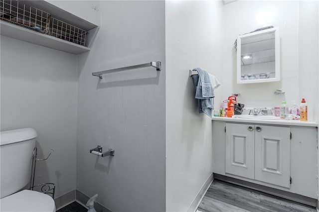 bathroom with vanity, toilet, and hardwood / wood-style floors