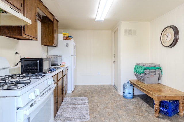 kitchen featuring white range with gas stovetop and wood walls