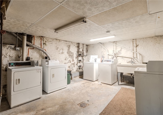 basement featuring washing machine and clothes dryer and sink