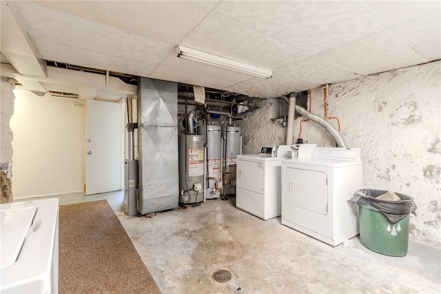 basement with heating unit, washer and clothes dryer, and water heater