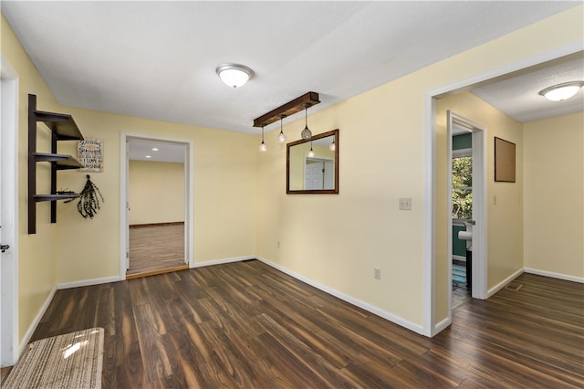 empty room featuring a textured ceiling and dark hardwood / wood-style flooring