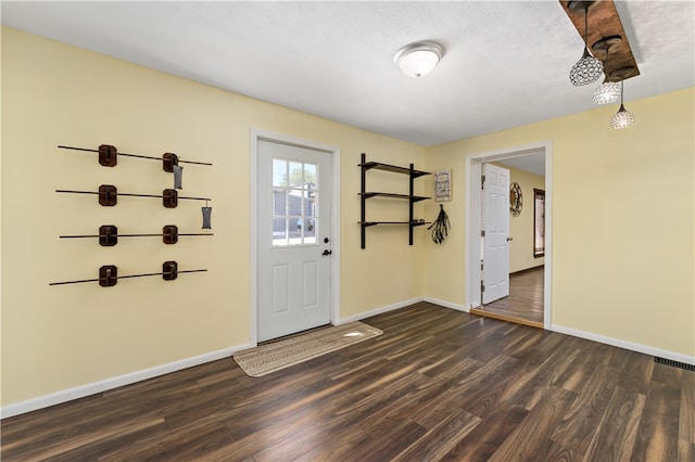 entrance foyer with a textured ceiling and dark wood-type flooring