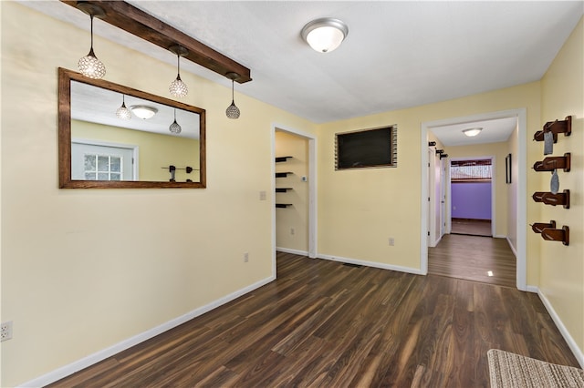 spare room with beamed ceiling and dark hardwood / wood-style flooring