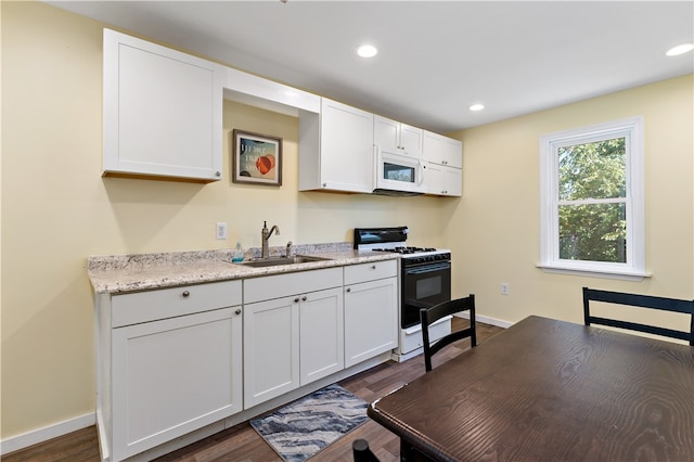 kitchen featuring dark wood-type flooring, white appliances, sink, and white cabinets