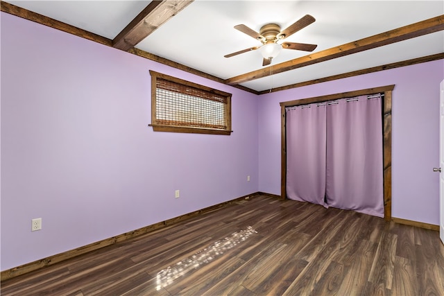 spare room featuring dark wood-type flooring, ceiling fan, and beamed ceiling