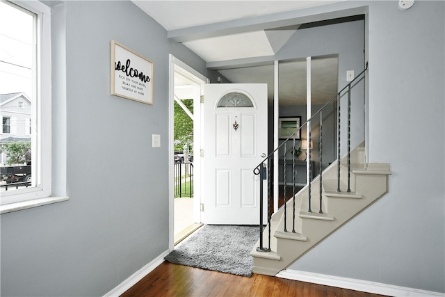 foyer featuring hardwood / wood-style flooring, beam ceiling, and a healthy amount of sunlight