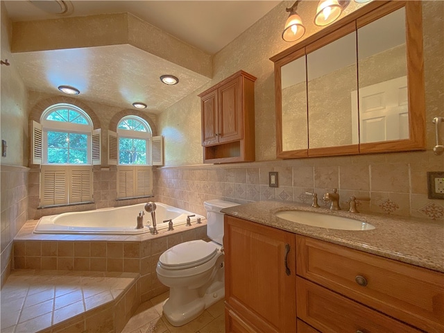 bathroom with toilet, tile patterned floors, vanity, a textured ceiling, and tiled bath