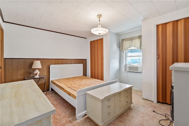 bedroom featuring wood walls, light colored carpet, and cooling unit