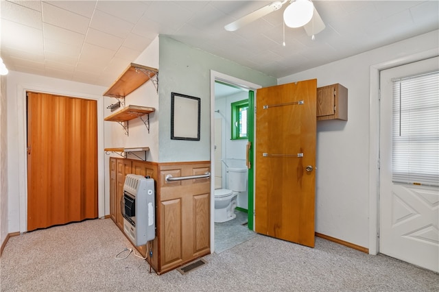 kitchen with plenty of natural light, ceiling fan, light carpet, and heating unit