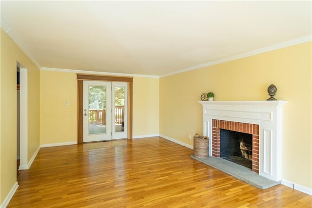 unfurnished living room with ornamental molding, a brick fireplace, and light wood-type flooring