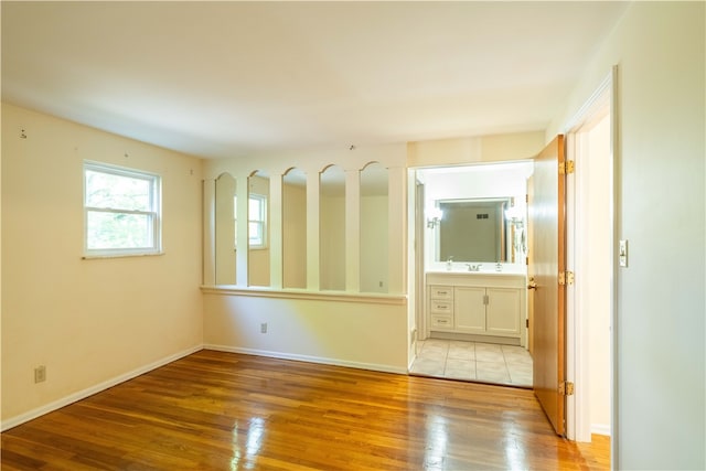 empty room featuring sink and light hardwood / wood-style floors