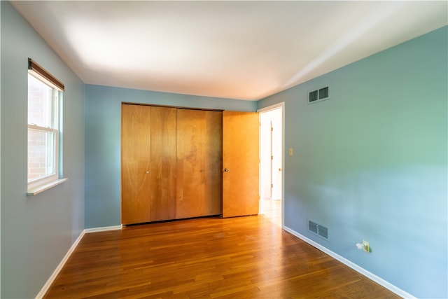 unfurnished bedroom with hardwood / wood-style flooring and a closet