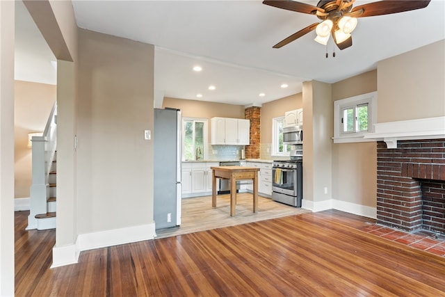 kitchen featuring ceiling fan, stainless steel appliances, white cabinetry, and light hardwood / wood-style flooring