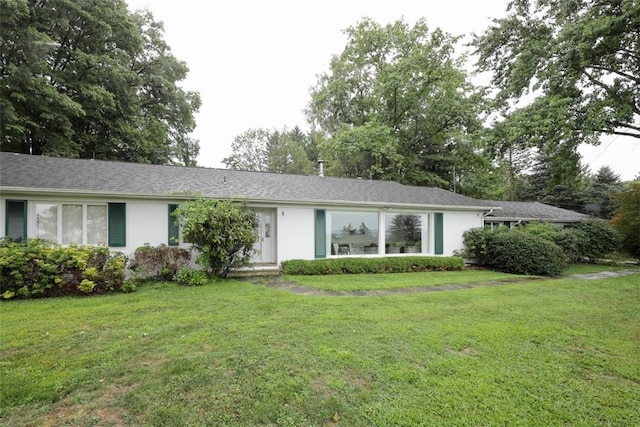 ranch-style house featuring a front lawn and stucco siding