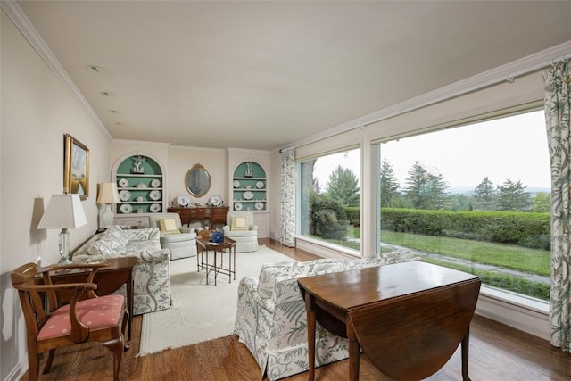 interior space featuring built in features, crown molding, and wood finished floors