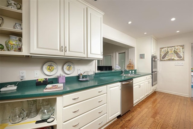 kitchen with light wood finished floors, open shelves, a sink, white cabinets, and appliances with stainless steel finishes