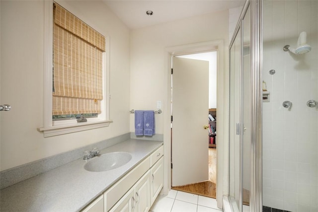 full bath featuring tile patterned floors, vanity, and a shower stall