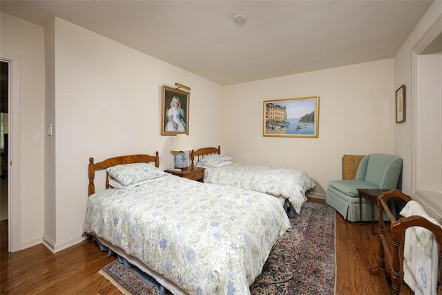 bedroom with wood finished floors and baseboards