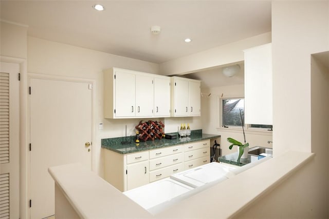 kitchen with dark countertops, recessed lighting, and white cabinetry