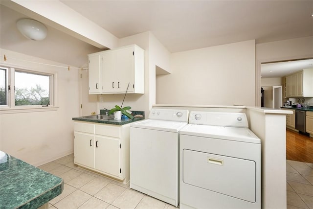 laundry room featuring light tile patterned floors and washing machine and dryer