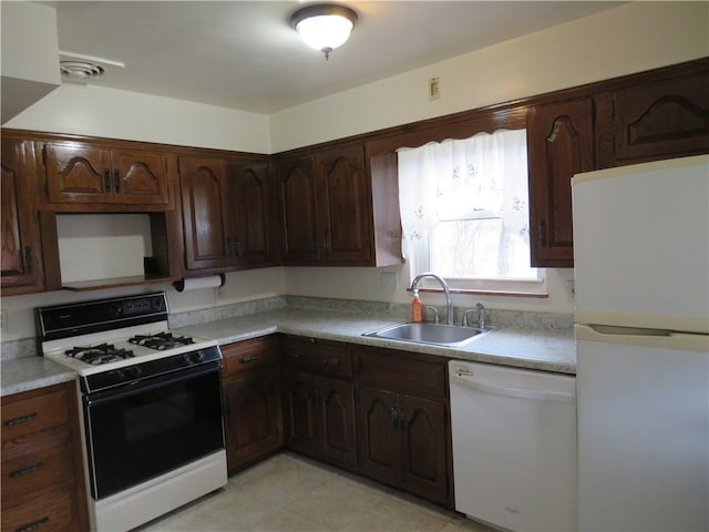 kitchen with white appliances, sink, dark brown cabinetry, and light tile patterned floors