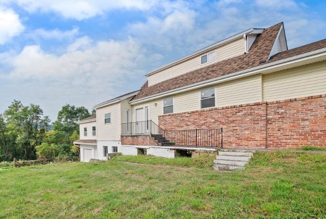 back of property featuring a yard and a garage