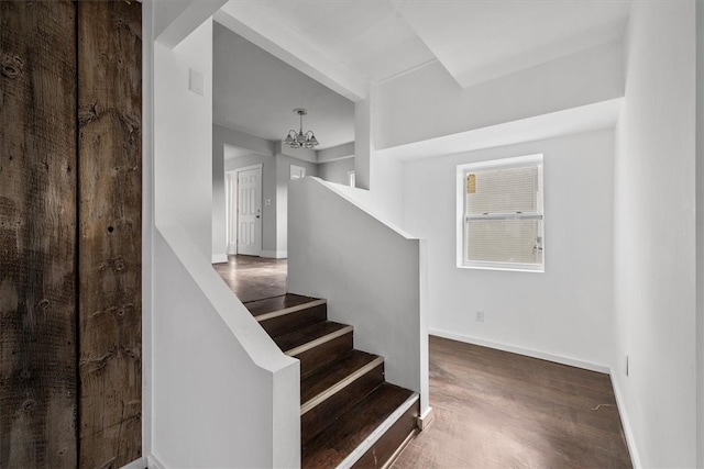 stairway featuring hardwood / wood-style floors and a chandelier