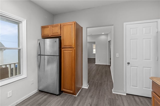 kitchen featuring a healthy amount of sunlight, stainless steel fridge, and wood-type flooring