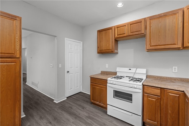 kitchen with white range with gas cooktop and dark hardwood / wood-style floors