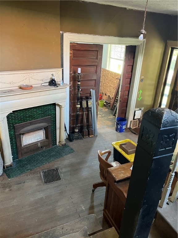 living room with a tiled fireplace and hardwood / wood-style floors