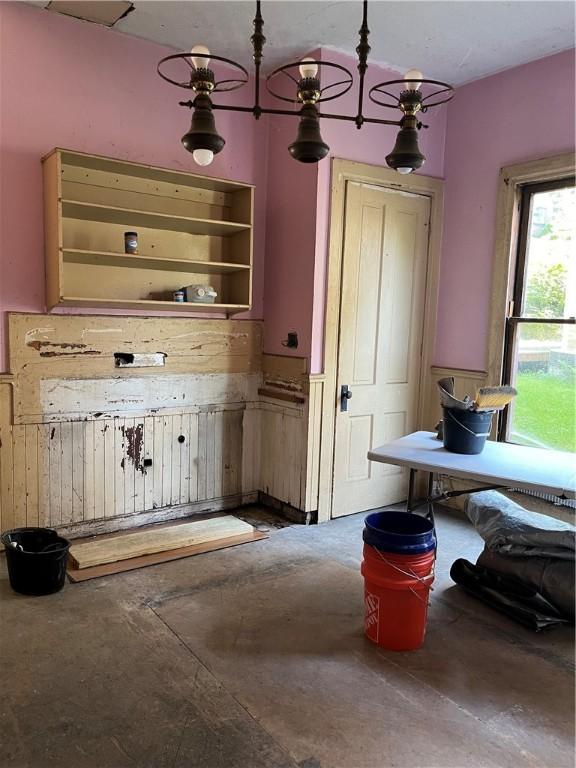 kitchen featuring concrete flooring and a wainscoted wall