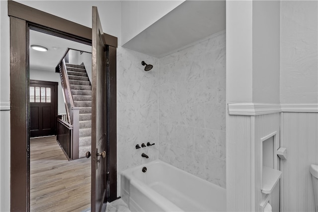 bathroom with toilet, hardwood / wood-style floors, and tiled shower / bath combo