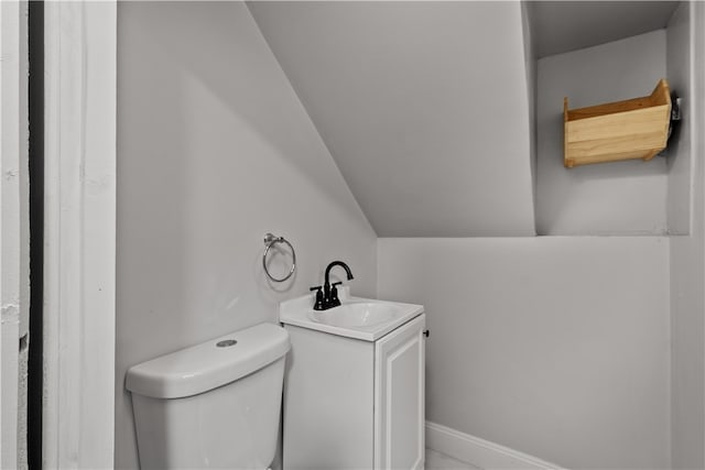 bathroom with vanity, lofted ceiling, and toilet