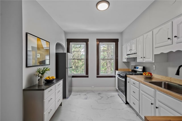 kitchen with stainless steel appliances, sink, and white cabinetry