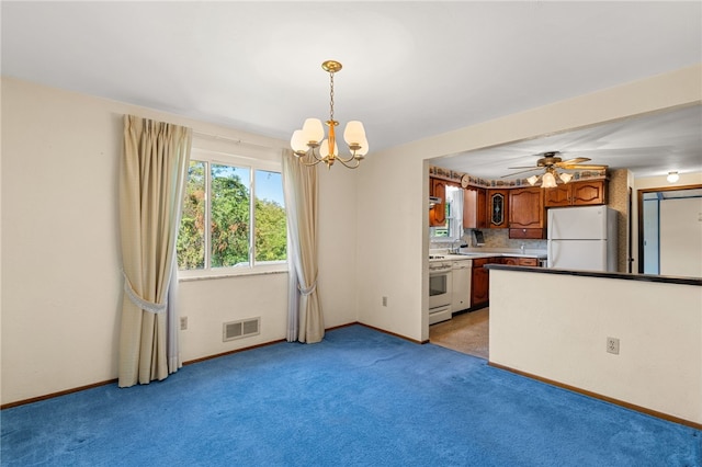 kitchen featuring pendant lighting, ceiling fan with notable chandelier, white appliances, tasteful backsplash, and light colored carpet