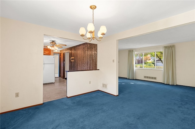 carpeted empty room featuring ceiling fan with notable chandelier