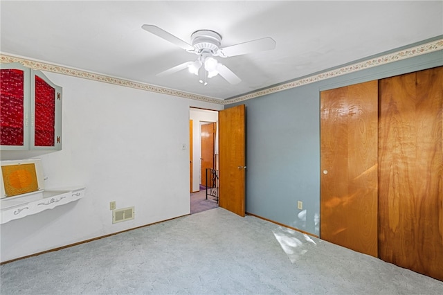 unfurnished bedroom featuring a closet, ceiling fan, and light colored carpet