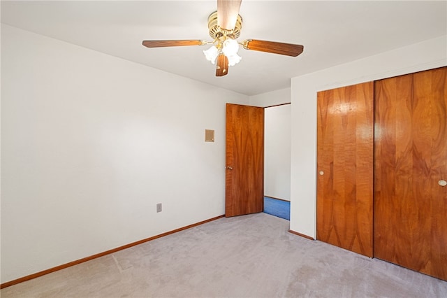 unfurnished bedroom with light carpet, ceiling fan, and a closet