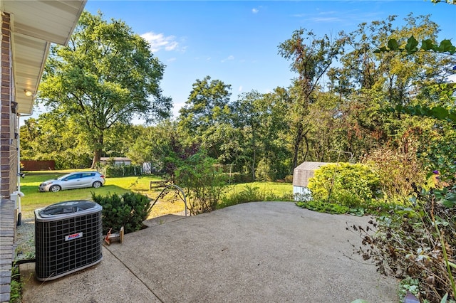 view of patio featuring cooling unit and a storage shed